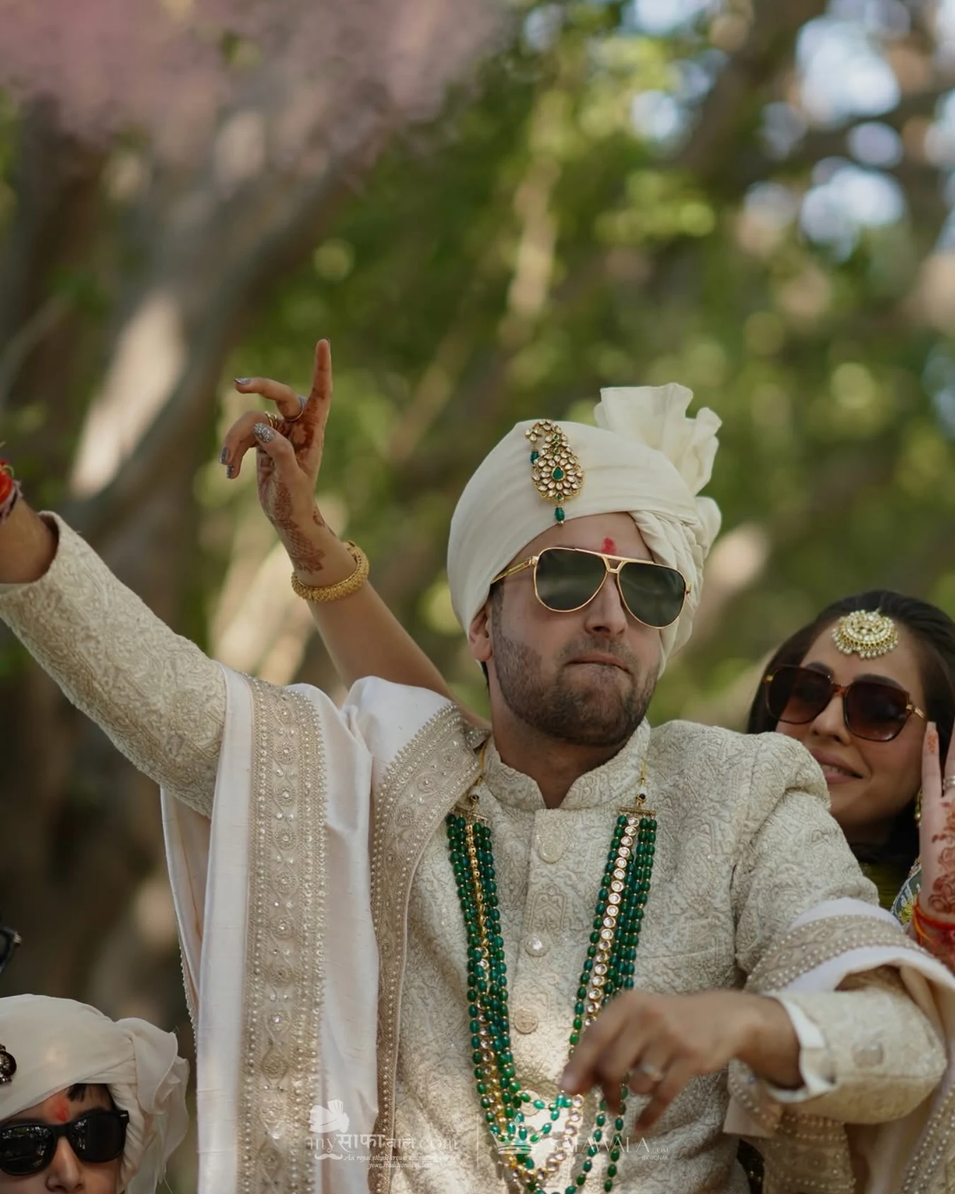 Groom in an ivory wedding safa with emerald jewellery for Groom Pagdi Styling
